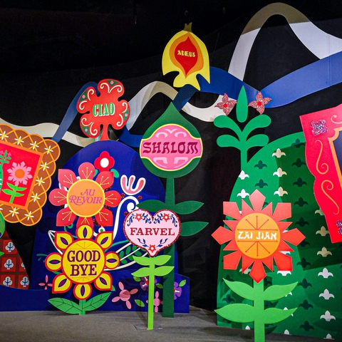 Photo shows several coloful banners that say hello in various languages